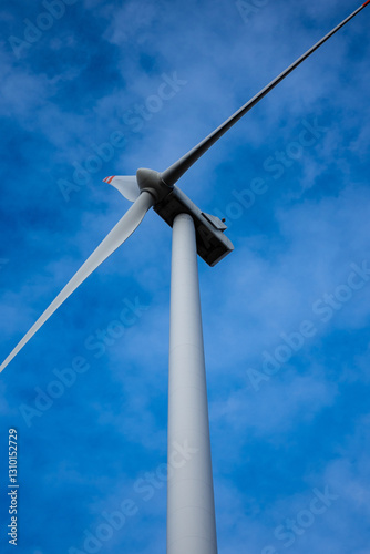 Obraz na płótnie White wind turbine rotor against a blue sky background. Electric generator photographed from below w salonie