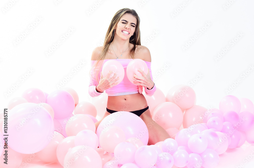Beautiful girl with long hair posing between pink air balloons. Happy birthday. Party mood. Sexy young woman in black lingerie with perfect makeup among inflated balloons. Beauty, fashion and style.