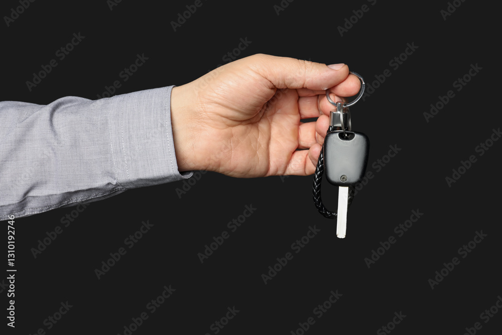 Woman with car key and keychain on black background, closeup Woman with car key and keychain on black background, closeup