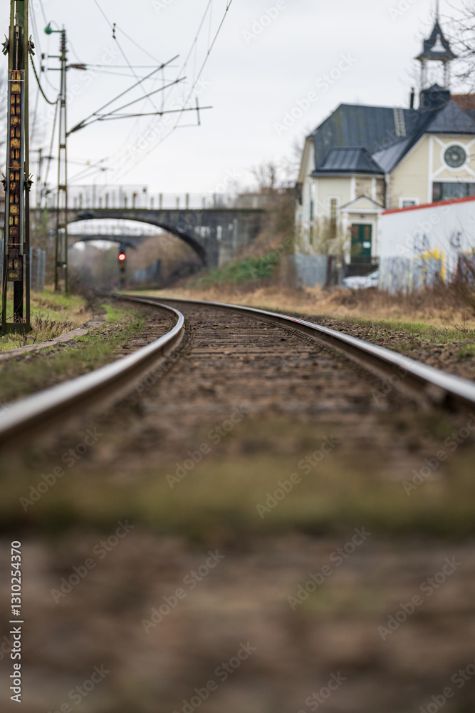 Fototapeta premium low-angle view of railway tracks curving towards a bridge.