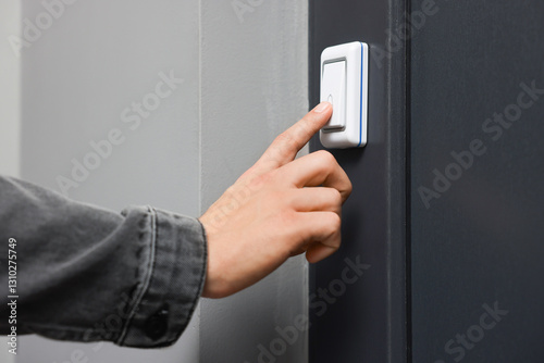 Man ringing doorbell of his friends apartment, closeup