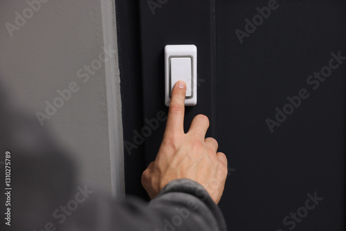 Man ringing doorbell of his friends apartment, closeup photo