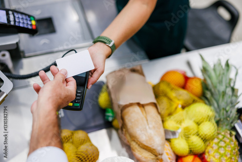 Fotografía Customer paying with contactless credit card at supermarket checkout