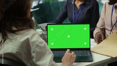Fotografie Diverse team of business associates looking at mockup chroma key screen during executive board meeting, utilizing smart technology