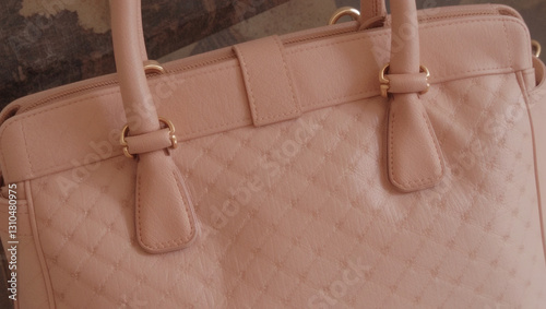 Stylish pink handbag with quilted texture, perfect for everyday use or fashion statement. photo