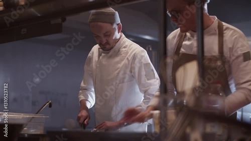 Men chefs preparing dishes while working in kitchen restaurant