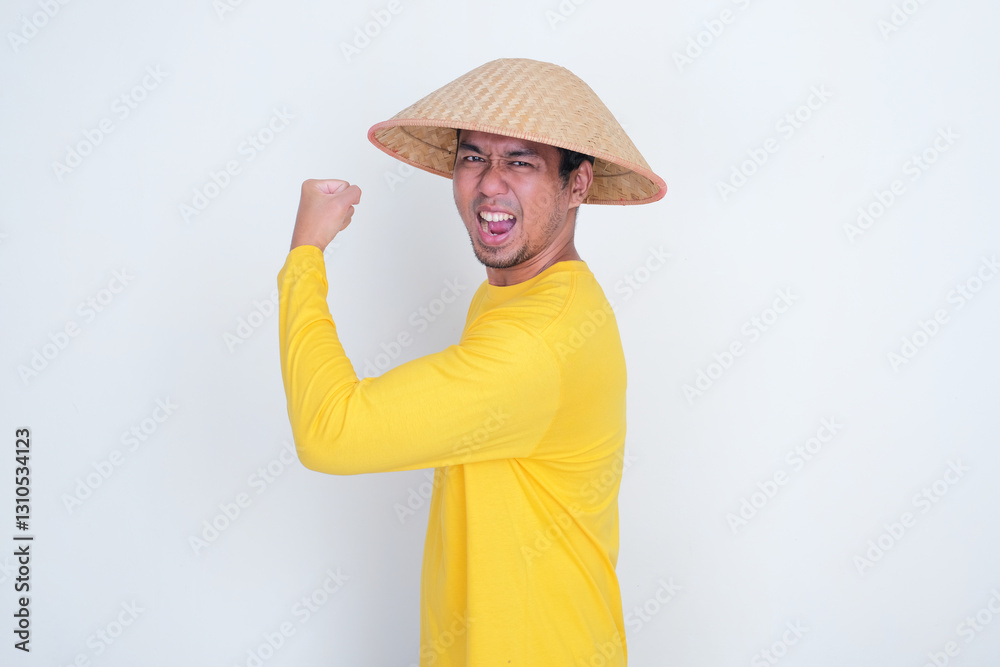 Side view of Indonesia farmer showing his arm biscep muscle with excited expression Side view of Indonesia farmer showing his arm biscep muscle with excited expression