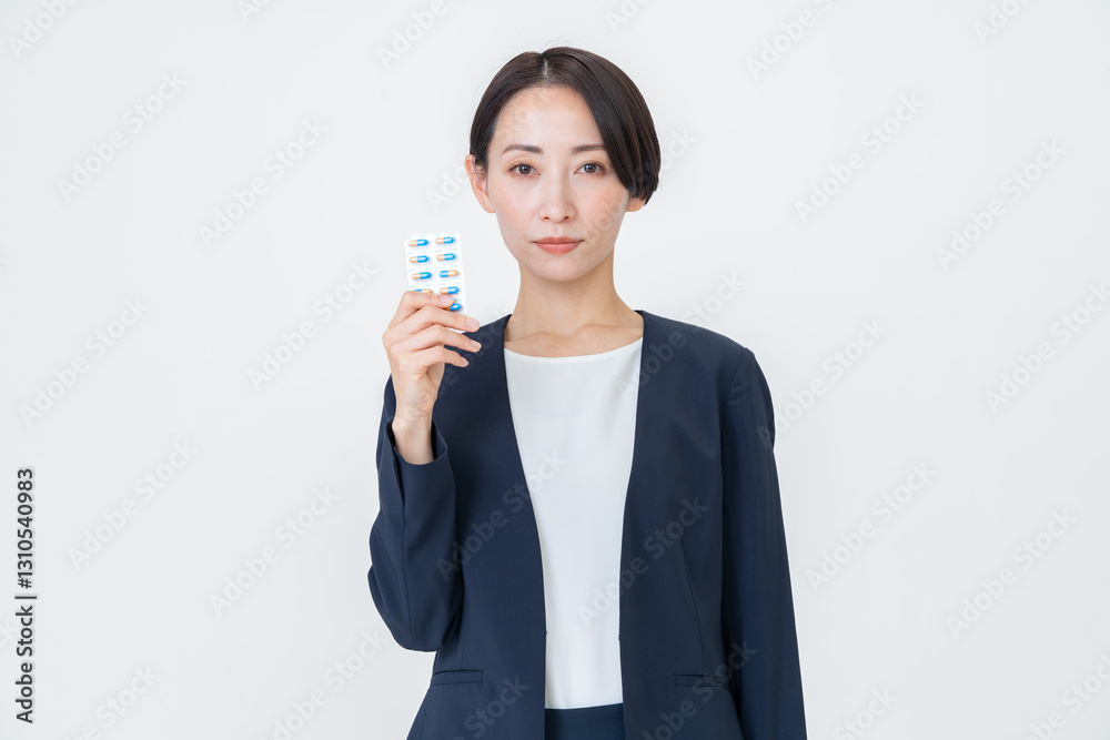 薬の錠剤を持つスーツを着た女性 薬の錠剤を持つスーツを着た女性