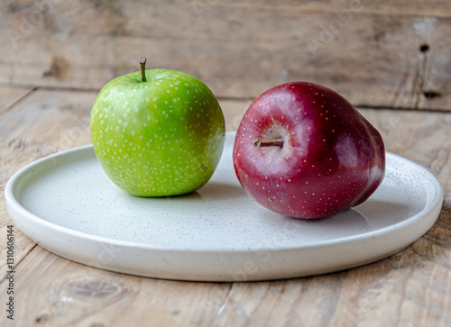green and red apples on  white plate on the kitchen table