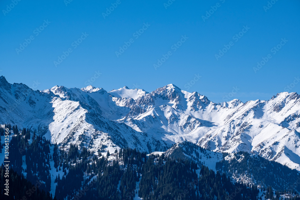 Obraz premium Snowy mountain peaks not far from Almaty, mountain views from kumbel peak. A popular tourist route in the mountains.