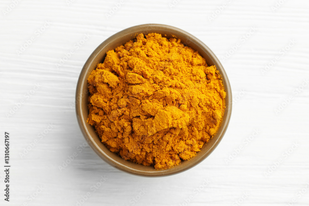 Turmeric powder in bowl on white wooden table, top view Turmeric powder in bowl on white wooden table, top view