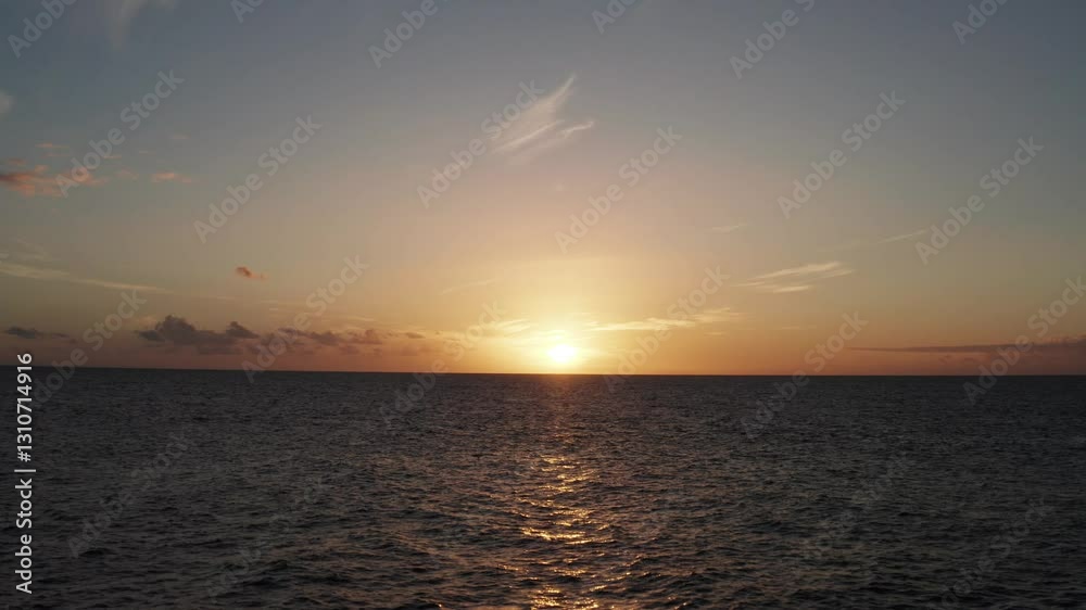 Epic aerial shot of sunset over the Atlantic Ocean with golden light reflecting on the waves, leading towards the horizon in a tranquil, cinematic scene. Drone pushing forward and gaining altitude. Epic aerial shot of sunset over the Atlantic Ocean with golden light reflecting on the waves, leading towards the horizon in a tranquil, cinematic scene. Drone pushing forward and gaining altitude.