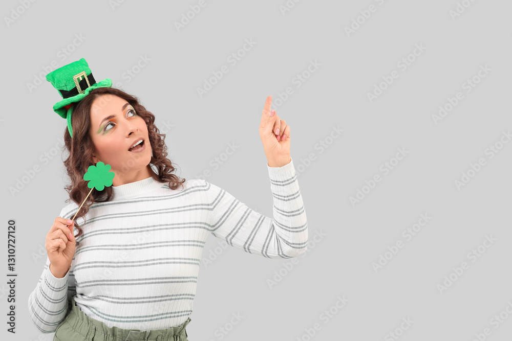 Happy woman with paper clover pointing at something on light background. St. Patrick's Day Happy woman with paper clover pointing at something on light background. St. Patrick's Day