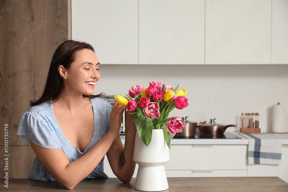 Happy young woman and vase with bouquet of beautiful tulips in kitchen. International Women's Day Happy young woman and vase with bouquet of beautiful tulips in kitchen. International Women's Day