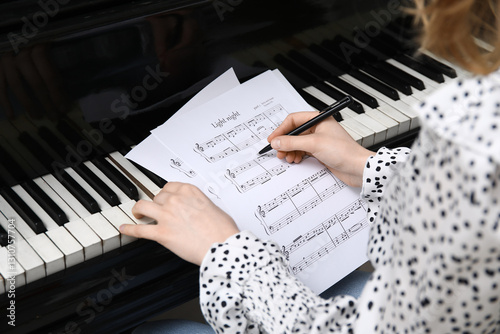 Woman playing piano and wri...