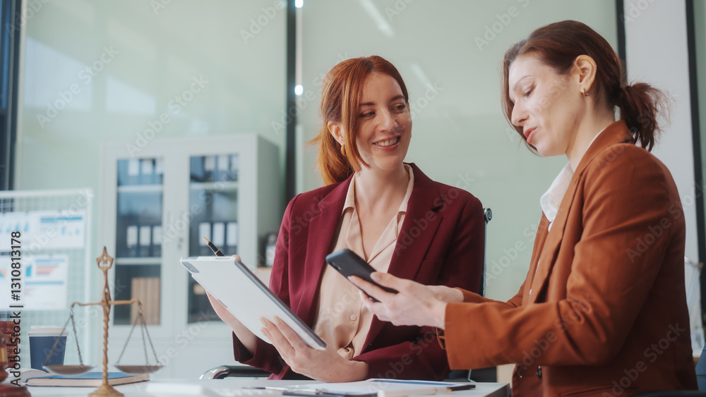 Two Caucasian women meet at a table, discussing legal matters. As lawyers, they advise clients on rights, responsibilities,business issues, representing them in criminal, civil, and regulatory cases Two Caucasian women meet at a table, discussing legal matters. As lawyers, they advise clients on rights, responsibilities,business issues, representing them in criminal, civil, and regulatory cases