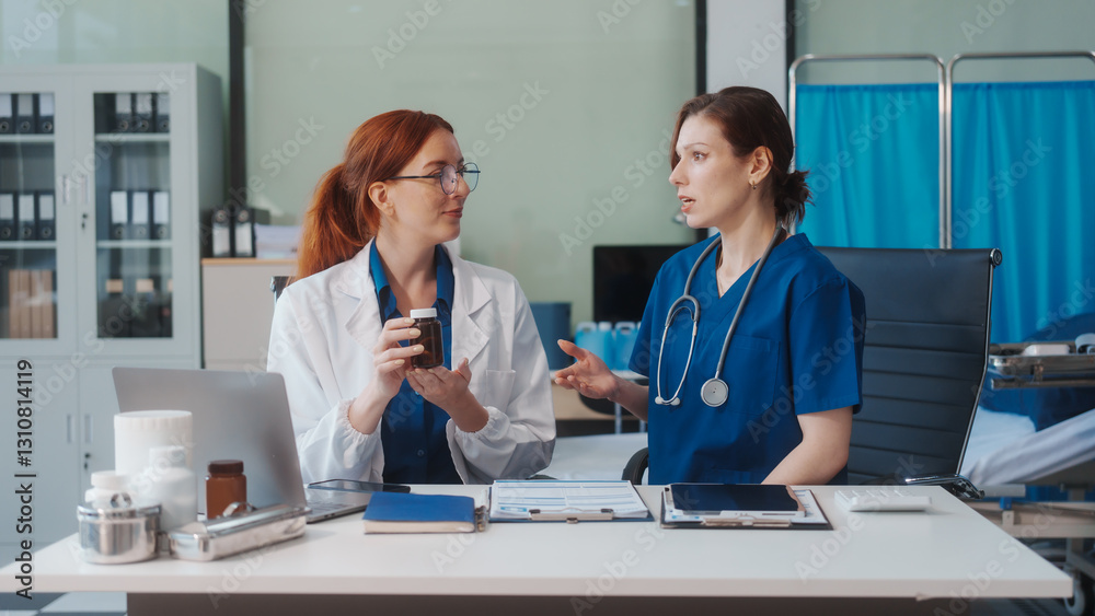Fototapeta premium Two Caucasian female doctors work at a desk, meeting and discussing patient treatment while using a medical program modern technology in a hospital to ensure effective healthcare medicine management