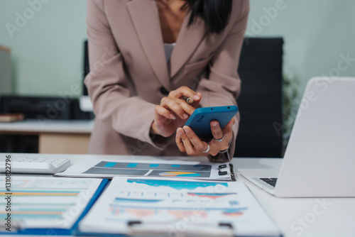 An Asian businesswoman accountant calculates invoices, taxes, interest, loans using a calculator,working online to guide clients through financial planning ensure a smooth loan process for success