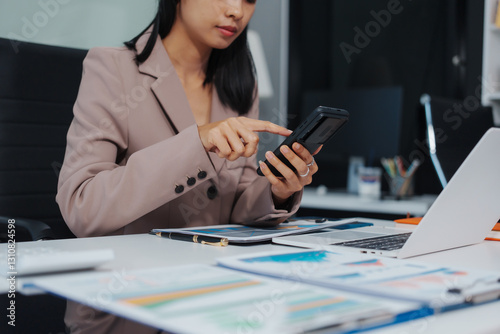 An Asian businesswoman accountant calculates invoices, taxes, interest, loans using a calculator,working online to guide clients through financial planning ensure a smooth loan process for success