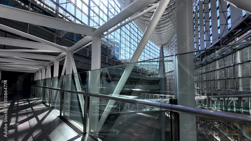 Sunlight illuminates the modern architecture of the Tokyo International Forum's walkway, creating a captivating interplay of light and shadow Sunlight illuminates the modern architecture of the Tokyo International Forum's walkway, creating a captivating interplay of light and shadow