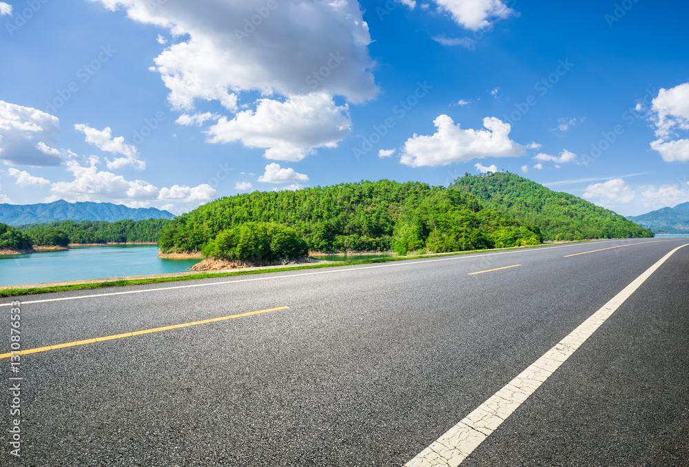 Empty asphalt road with beautiful lake and mountain under blue sky