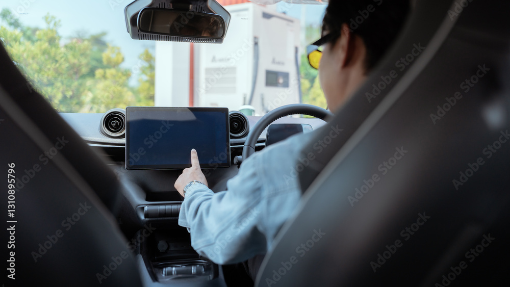 Driver interacts with touchscreen display in modern vehicle while parked in a city setting