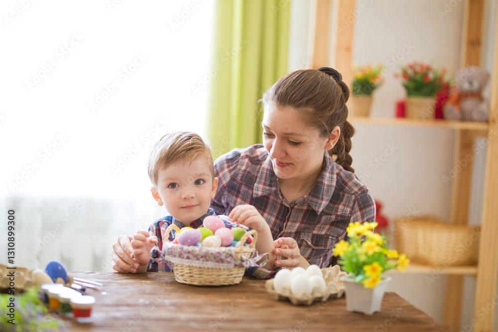 A woman and a child are happily decorating Easter eggs together A woman and a child are happily decorating Easter eggs together