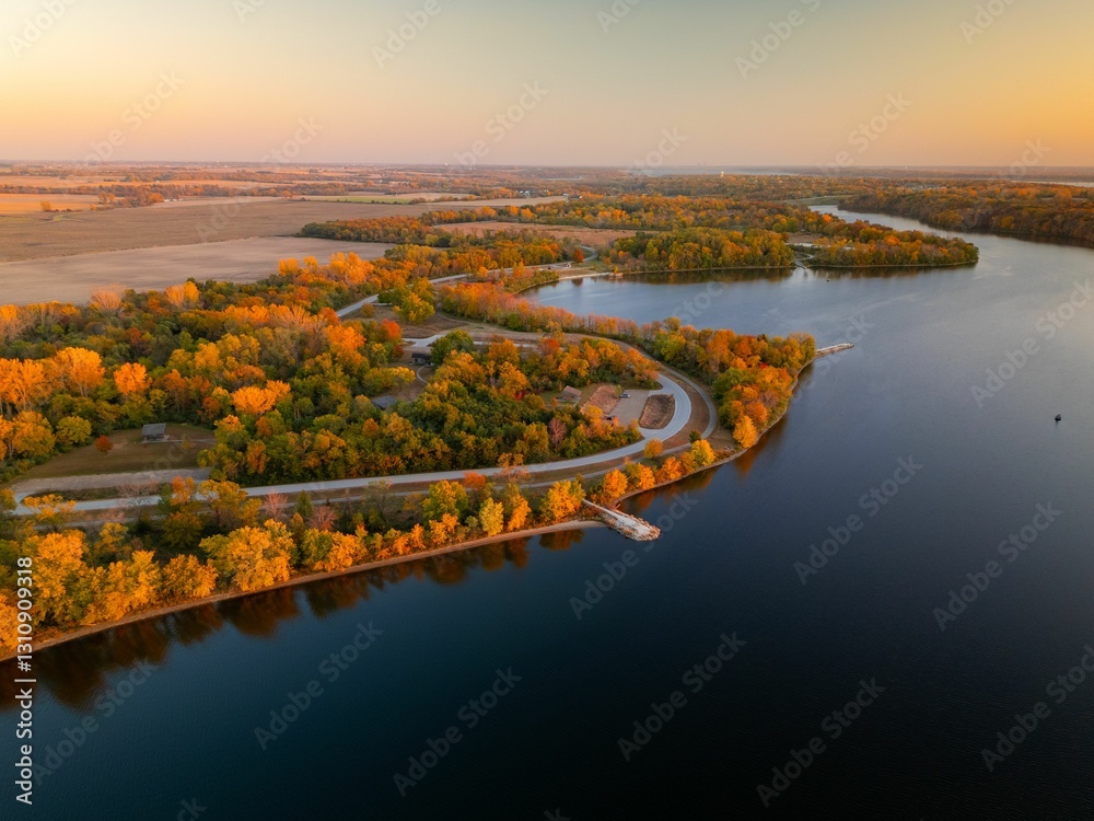 Fototapeta premium Aerial view of autumn landscape with vibrant foliage surrounding Big Creek State Park, Polk City, IA