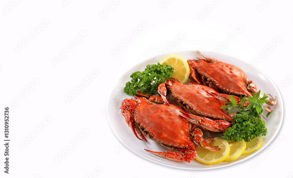 Fresh sea crab with vegetables and lemon garnish on a white plate placed on a white background. Fresh sea crab with vegetables and lemon garnish on a white plate placed on a white background.