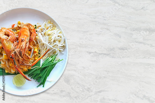 Pad Thai  Stir-fried rice noodles with river prawns in sauce on a plate on a marble table