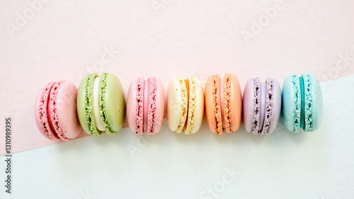 Row of colorful French macarons arranged neatly on a pastel background.