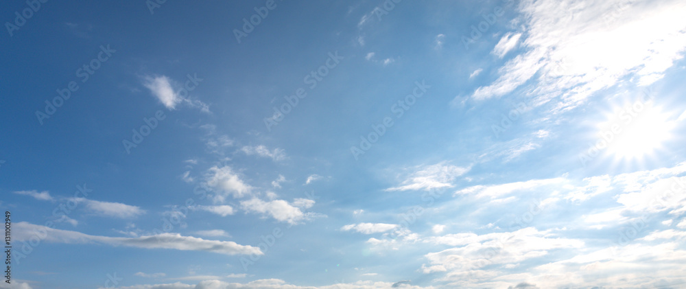 Obraz premium Clear blue sky with a few clouds and a sun shining brightly