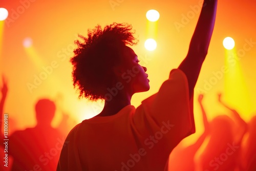Silhouette of dancer against vibrant orange lights, capturing jo