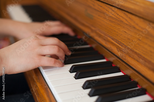 Child's Hands Playing Wooden Piano Keys

