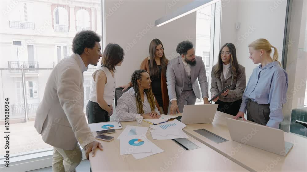 Diverse arrangement of skilled professionals are engaging dynamically around a laptop in a sleek, modern office environment, effectively showcasing the essence of teamwork and collaboration