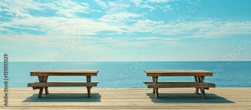 Serene ocean view from vacant wooden tables on a boardwalk with turquoise waters and a clear blue sky enhancing the tranquil atmosphere.