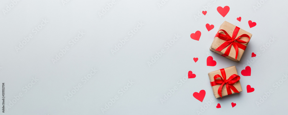 Valentine day composition: red gift box with bow and heart. Christmas present. View from above. Space for text. Holday greeting card Valentine day composition: red gift box with bow and heart. Christmas present. View from above. Space for text. Holday greeting card