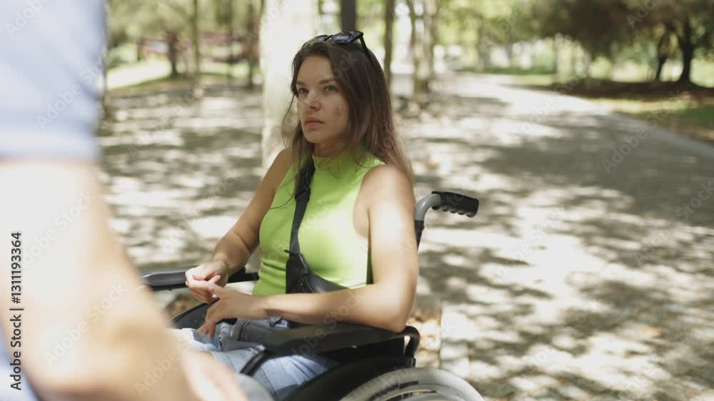 Woman using wheelchair talking to friend in slow motion Woman using wheelchair talking to friend in slow motion