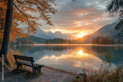 Fototapeta Naklejka Na Ścianę i Meble -  Empty bench observing stunning autumn sunrise over lake and mountains