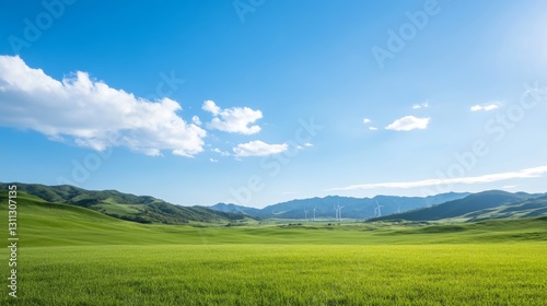 Wide open field under a vibrant sky with wind turbines on the horizon