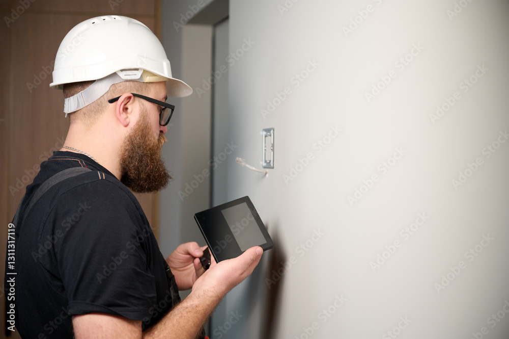 Security alarm installation. Security technician installing safe monitor on wall in the new office. Installing security system. Man worker installing alarm technology insurance in home Security alarm installation. Security technician installing safe monitor on wall in the new office. Installing security system. Man worker installing alarm technology insurance in home