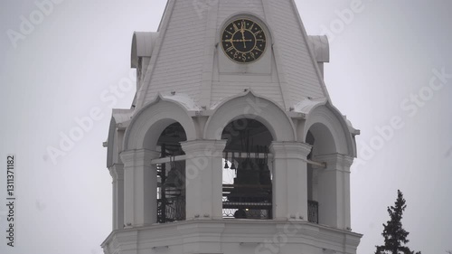 Clock face on the bell tower of a white Orthodox church