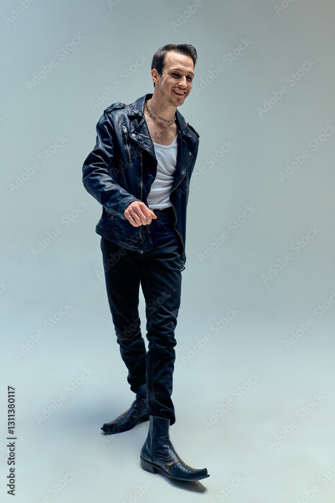 Confident young man walking forward with relaxed smile, exuding effortless charisma against minimalist background. Concept of vintage, attitude, music, charm, presence. Confident young man walking forward with relaxed smile, exuding effortless charisma against minimalist background. Concept of vintage, attitude, music, charm, presence.