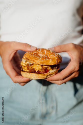 Smashed cheeseburger with sesame bun outdoors in summer