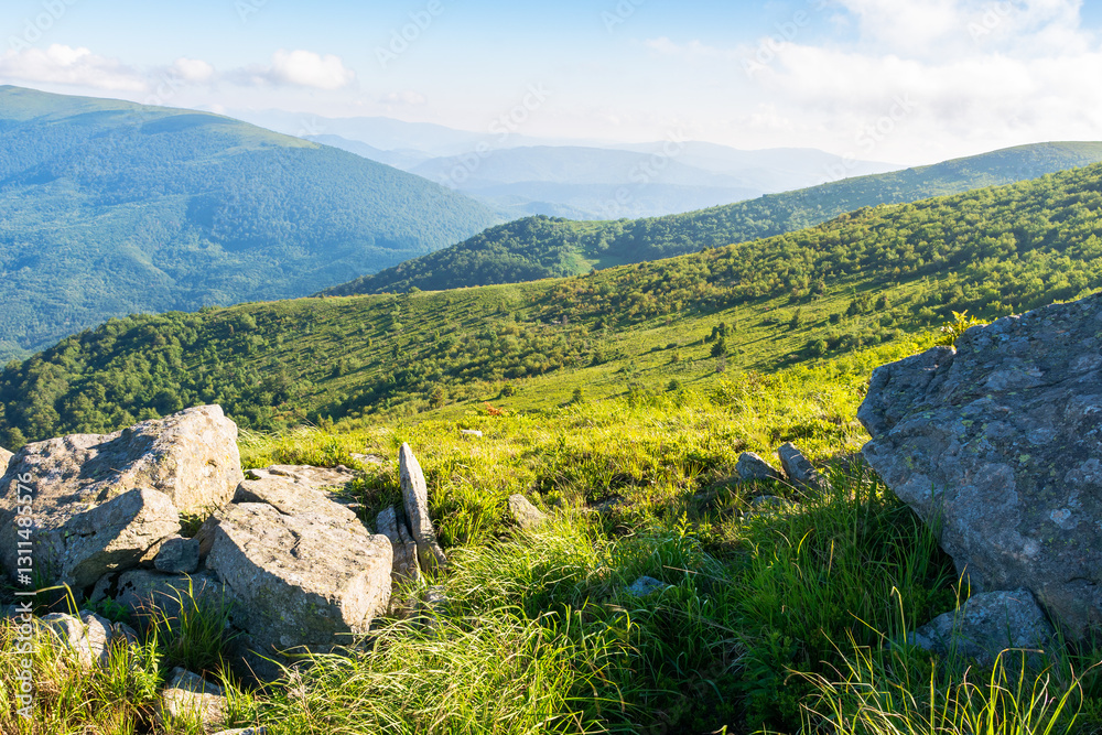 rolling landscape with stones on the grassy slope. sunny morning. beautiful alpine scenery of carpathian mountain smooth in summer. clouds on the bright blue sky. scenic view in to the distant valley
