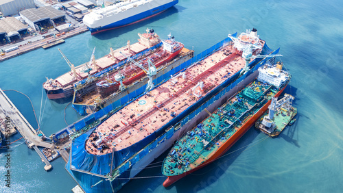 Oil tanker ship at dry dock concept maintenance service. working at dry dock. Insurance and Maintenance Crude tanker Ship concept. Freight Forwarding Service maintenance Insurance. photo