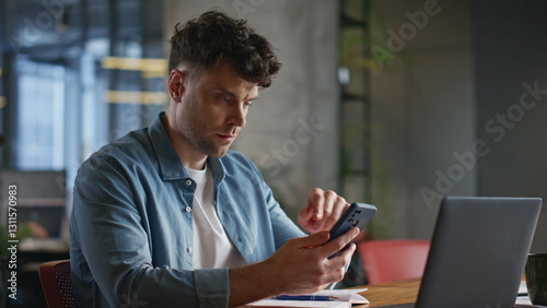 Wallpaper Mural Focused businessman looking smartphone reading messages at laptop table closeup Torontodigital.ca