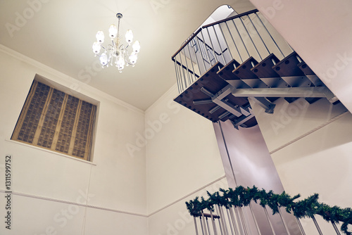 Elegant and modern staircase with black metal handrails and wooden steps in a luxurious penthouse with minimalist decor. High quality photo