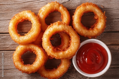 Deliciously fried food close-up view of crispy onion rings with ketchup dip on rustic wooden surface perfect for food lovers and culinary photography photo