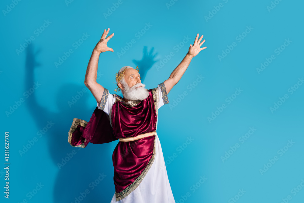 Photo of attractive old man cast spell magic dressed greek god emperor actor costume isolated on blue color background Photo of attractive old man cast spell magic dressed greek god emperor actor costume isolated on blue color background